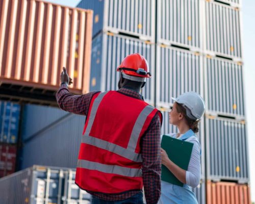 Foreman control loading Containers box from Cargo freight ship for import export. Freight containers in sea port.